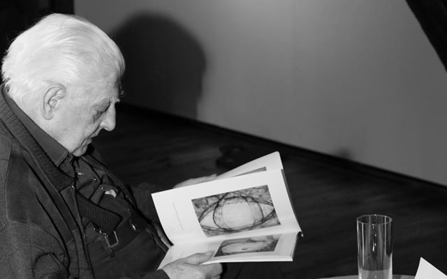 Wojciech Luterek przeglądający katalog wystawy
