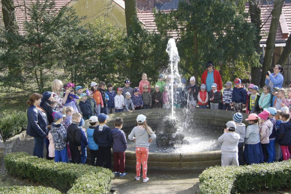 dzieci i dorośli zgromadzeni wokół fontanny