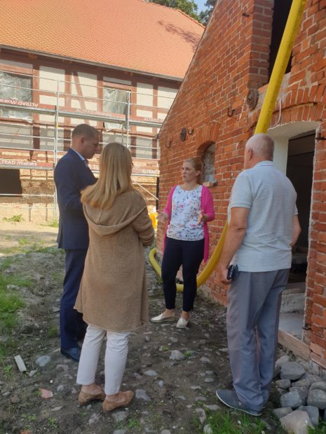 W trakcie rozmowy wicemarszałek Województwa Lubuskiego, dyrektor i wicedyrektor Muzeum oraz przedstawiciel wykonawcy remontu. W tle budynek młyński i budynek gospodarczy.